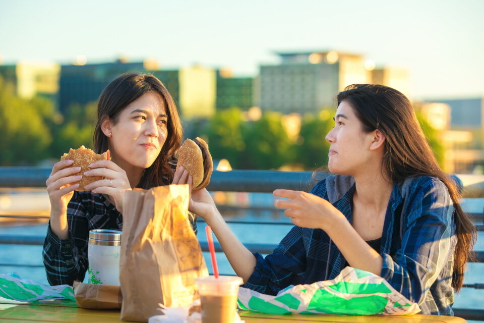 ファストフードを食べる若い女性たち