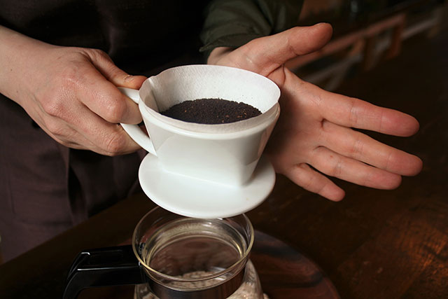 ドリッパーをトントンと手のひらで軽くたたいてコーヒー粉の表面を平らにします。
