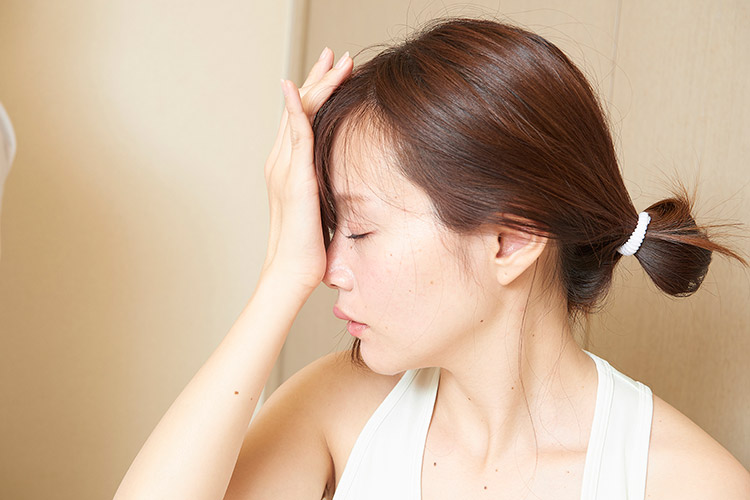 中指を軽く曲げて頭に触れる所にあるツボ「上星(じょうせい)」の写真